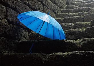 雨が降る石階段に青い傘