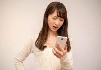 スマホを見てがっかりしている女性