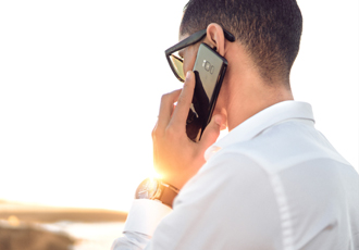 外でスマホを耳に当てている男性の後姿